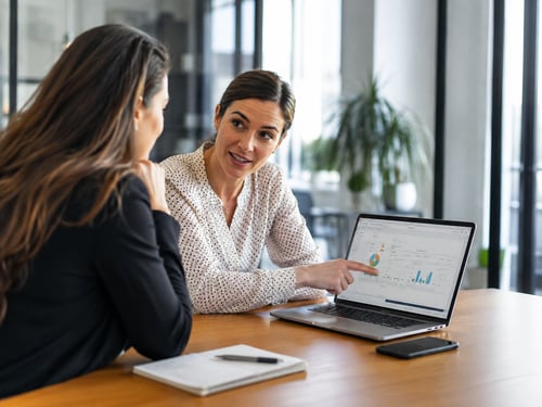 Payroll professional showing a client payroll and reporting information on a laptop.